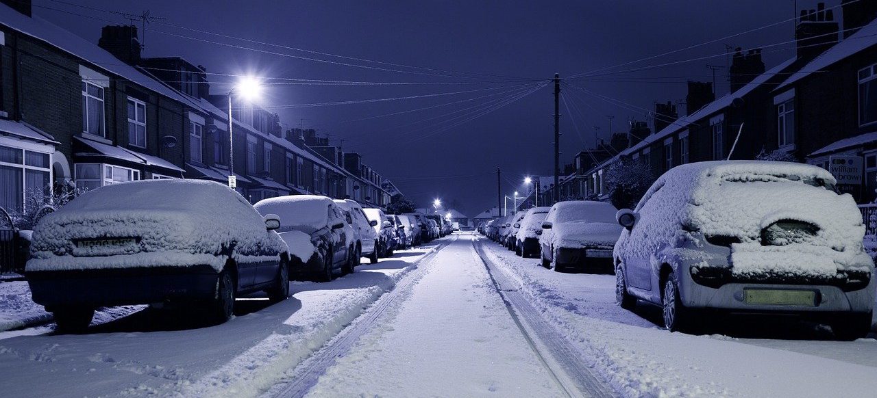 Cars parked on a street covered in snow